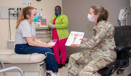 Army Maj. (Dr.) Kayla Jaeger, Adolescent and Young Adult Medicine chief, discusses contraception options with patient, Air Force Capt. Jacqueline Wade, while Benesha Jackson, licensed vocational nurse, gathers instruments for an exam at the CPT Jennifer M. Moreno Primary Care Clinic, Fort Sam Houston, Texas. U.S. Army photo by Jason W. Edwards.
